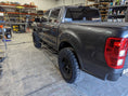 Load image into Gallery viewer, a truck parked inside of a garage next to a shelf of tools