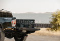 Load image into Gallery viewer, a black truck parked on a dirt road next to a body of water
