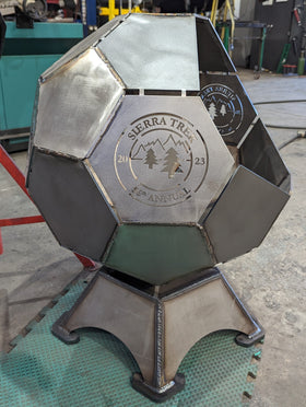 Metallic geometric sculpture with 'Sierra Tree' branding in a workshop setting