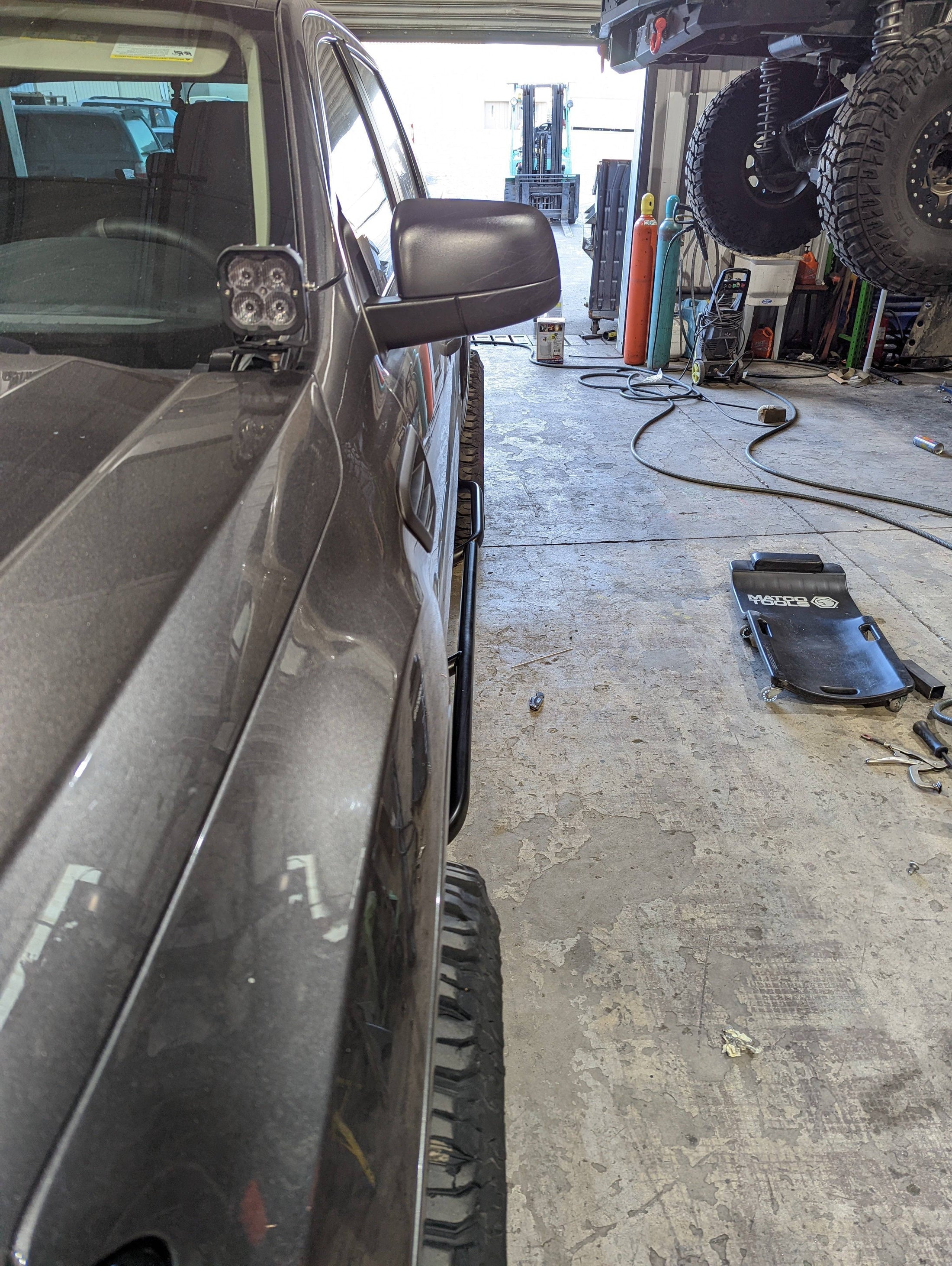 a truck parked inside of a garage next to a pile of tires