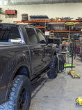 Load image into Gallery viewer, a truck parked inside of a garage next to other vehicles
