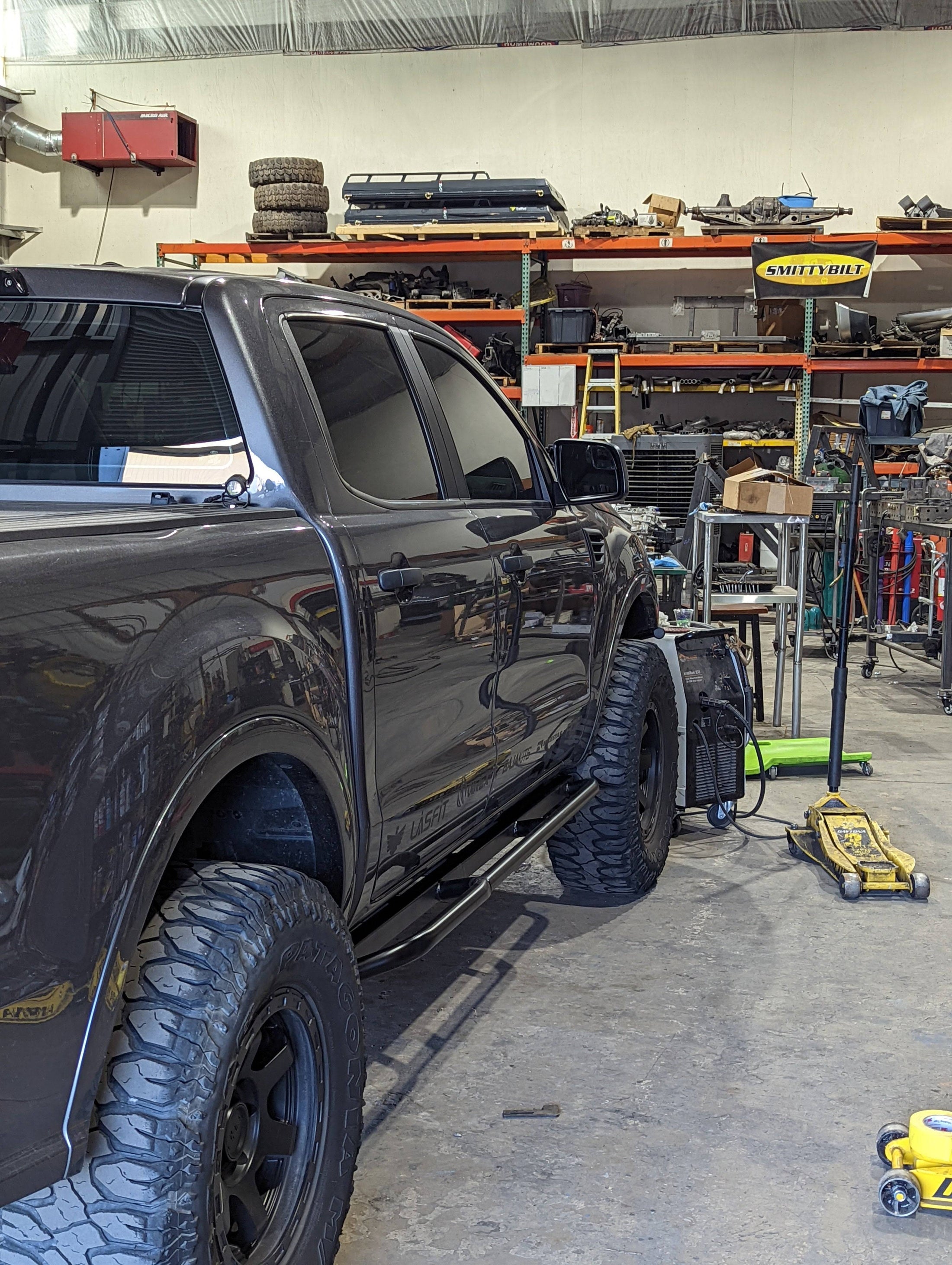 a truck parked inside of a garage next to other vehicles