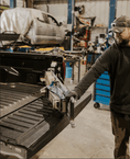 Load image into Gallery viewer, a man standing next to a truck in a garage
