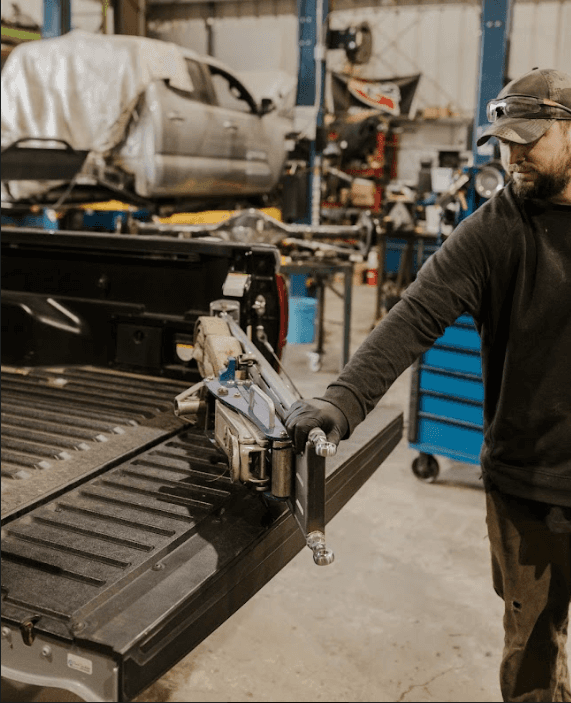 a man standing next to a truck in a garage